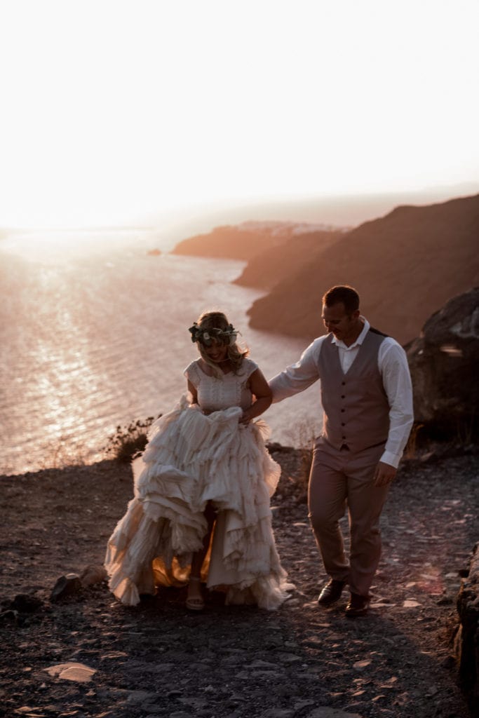 Bride and groom walk cliffsides of Greece after Santorini elopement