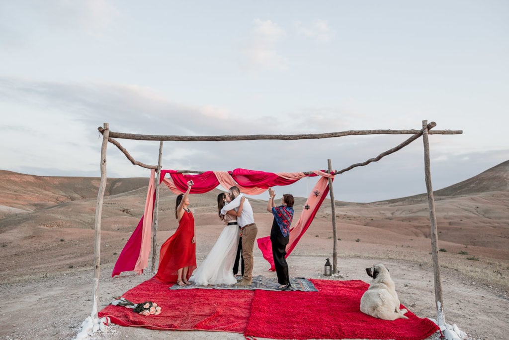 Bride and groom kiss after La Pause wedding ceremony in the desert of Morocco
