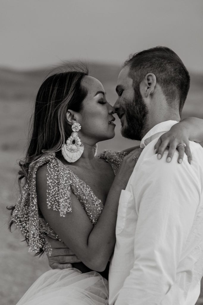 Bride and groom pose for their "just married' portrait in the desert