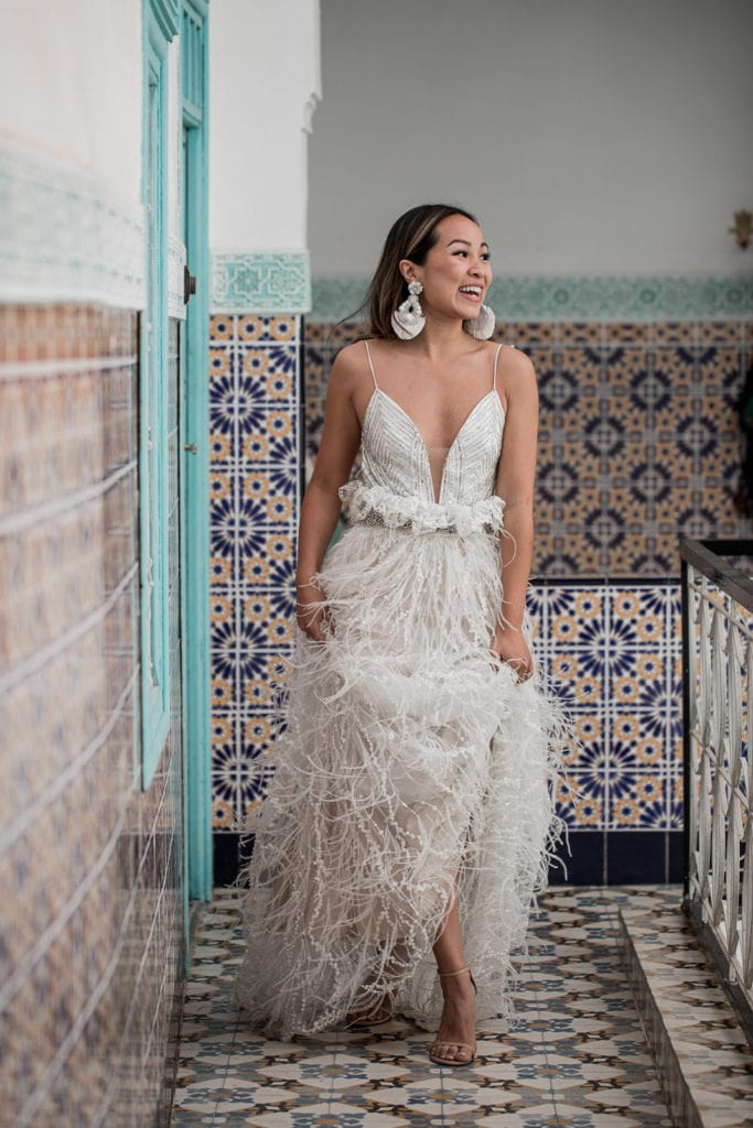 Bride wears beautiful bridal gown with feathered skirt for Morocco destination wedding