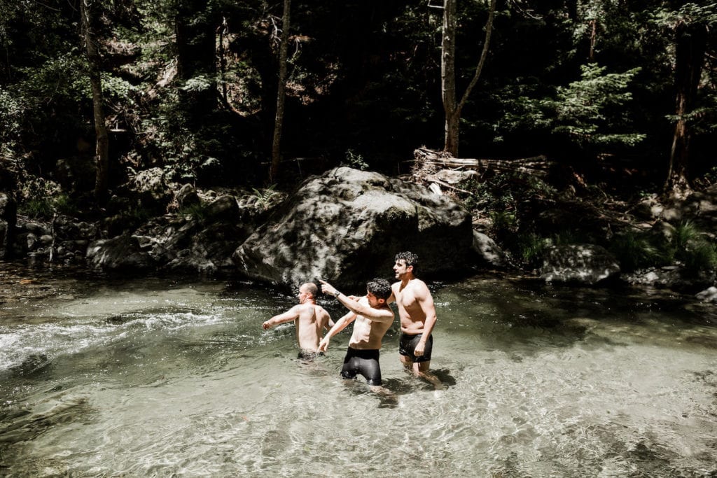 Groom and groomsmen hang out in crystal water spring at Glen Oaks, Big Sur wedding venue
