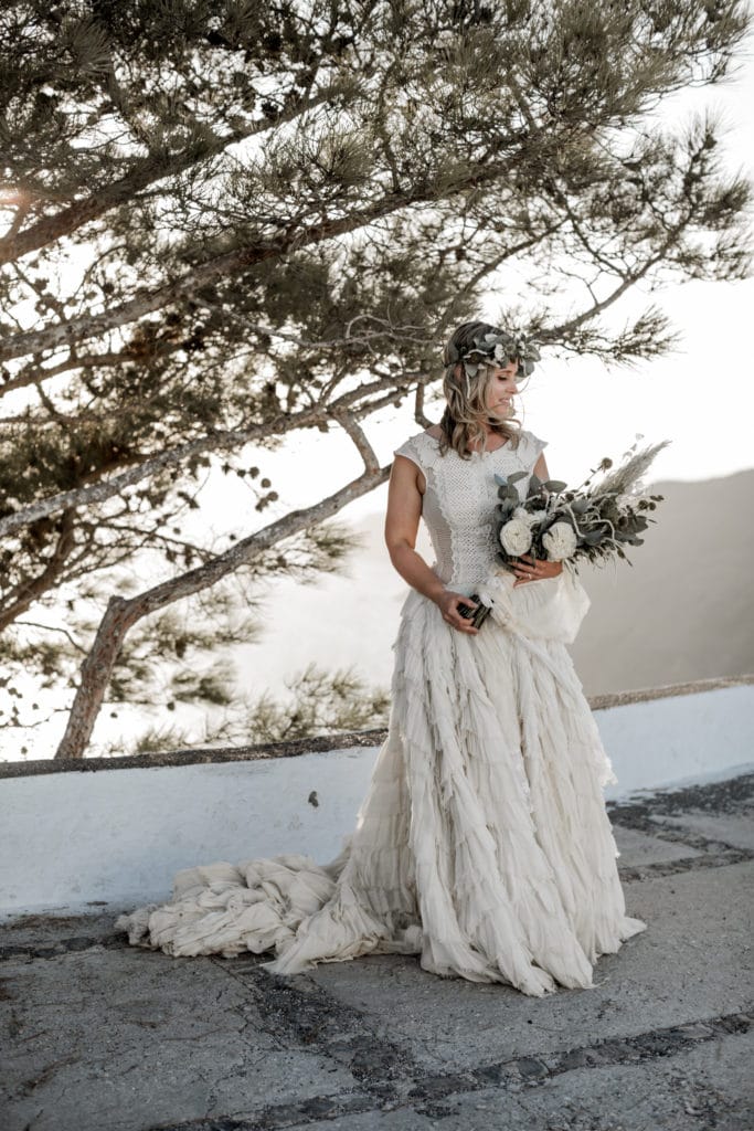 Bride holds bouquet before Santorini, Greece elopement ceremony