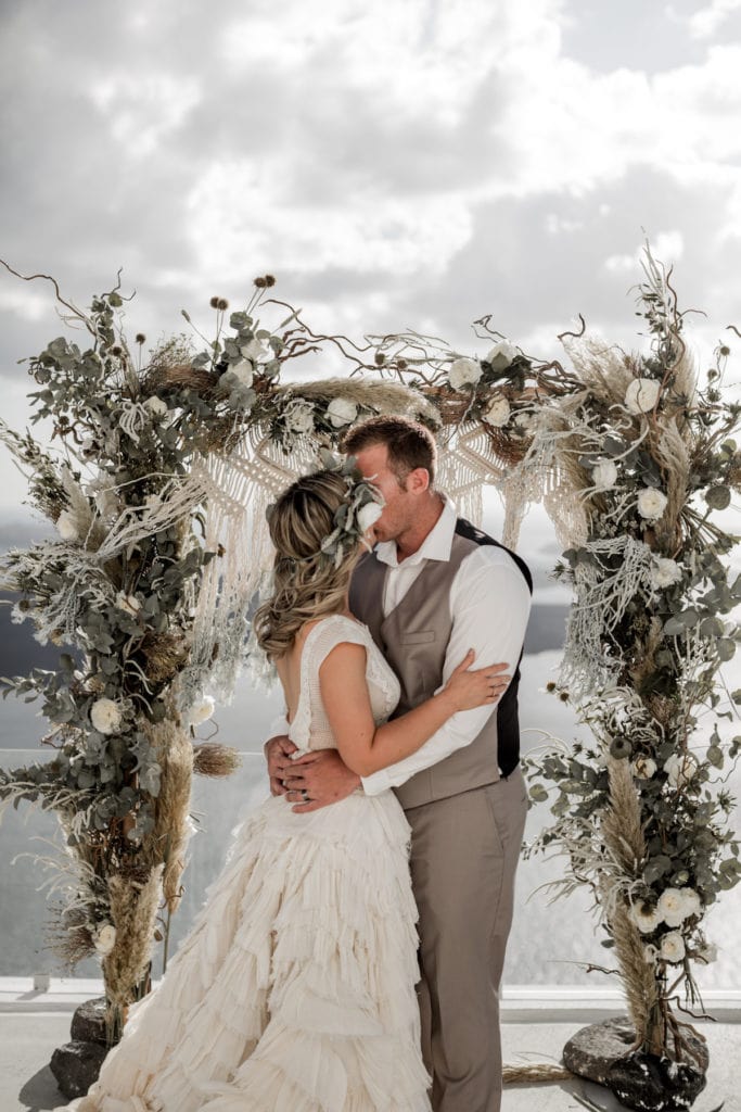 Bride and groom kiss at altar for Santorini, Greece elopement