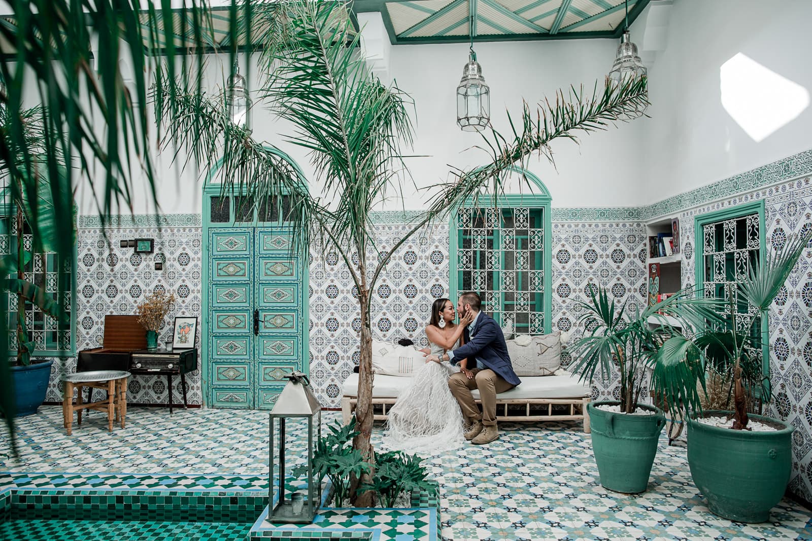 Bride and groom sit together in Be Riad in Marrakech, Morocco before wedding ceremony