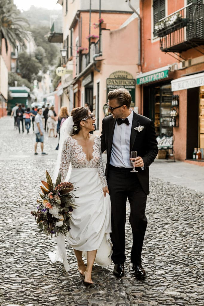 Bride and groom walking streets of downtown Portofino, Italy after wedding