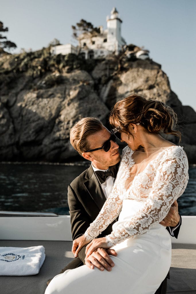 Bride and groom sitting on boat during sunset portraits in Cinque Terre, Italy