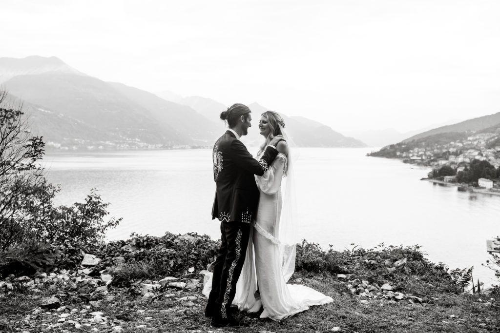 Bride and groom stand together for portrait at Giardini del Merlo overlooking Lake Como