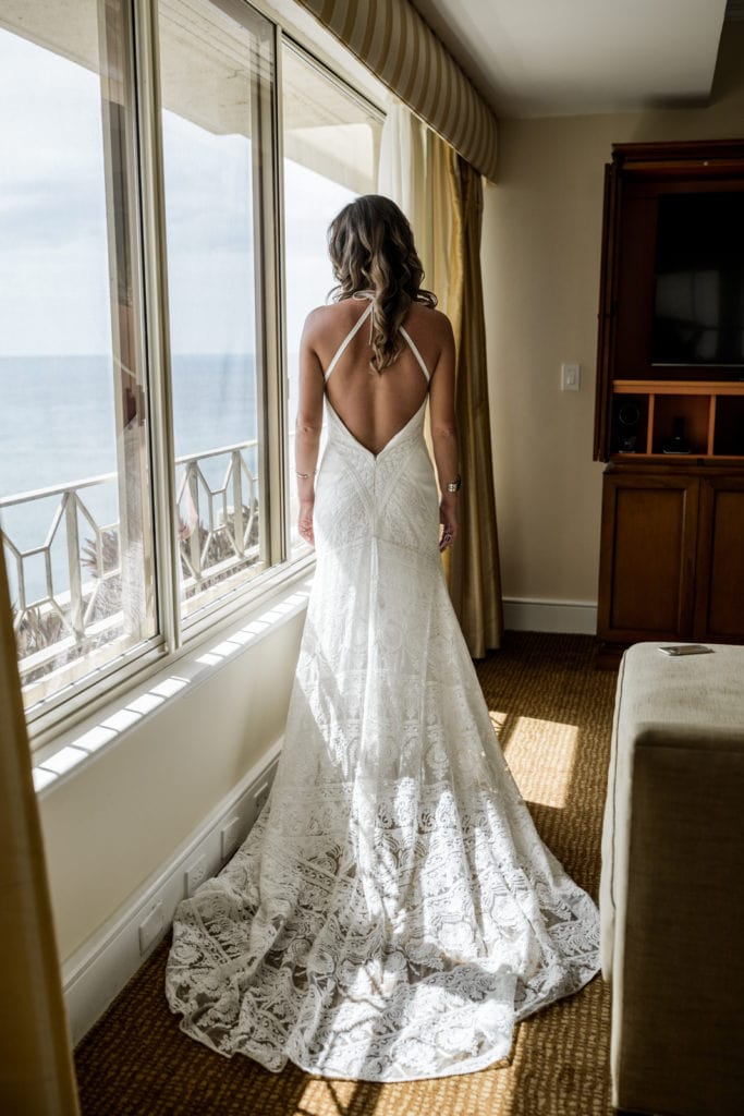 Bride shows the back of her wedding gown