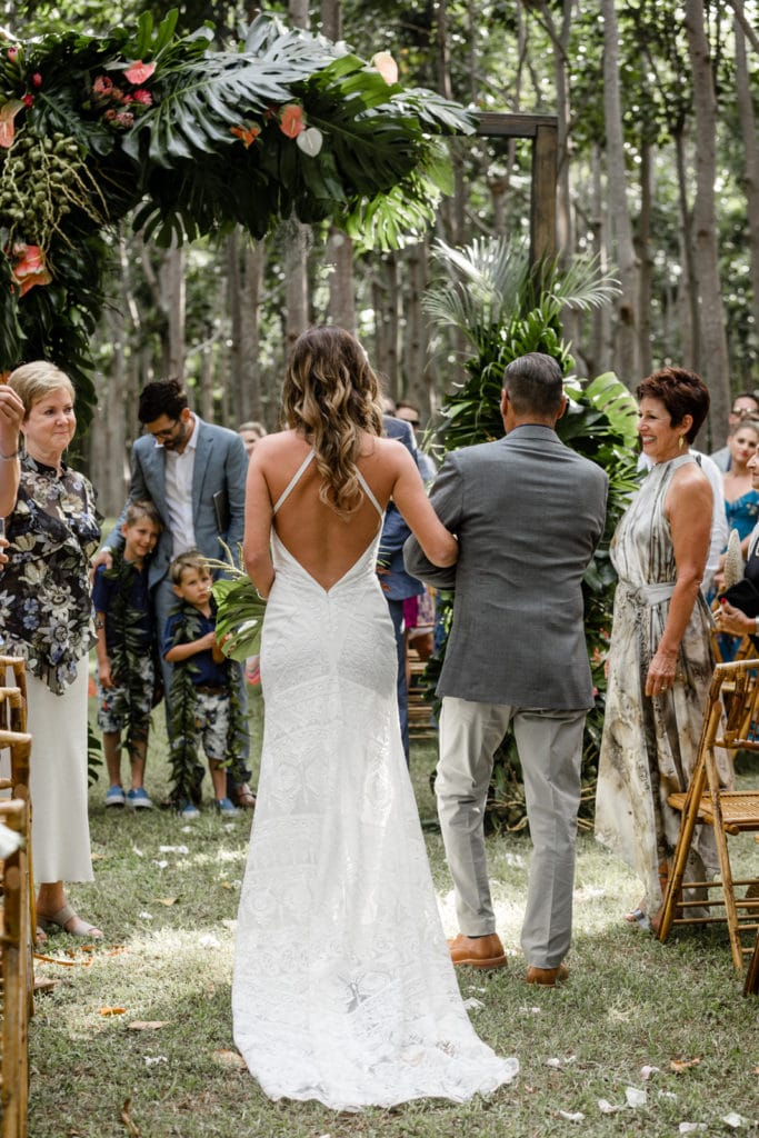Bride walks down the aisle with her father at her Na 'Aina Kai Botanical Gardens wedding