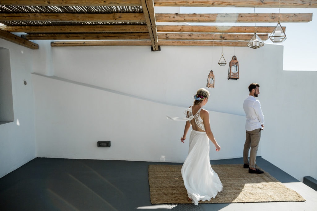 Bride walks up to groom during Santorini elopement first look