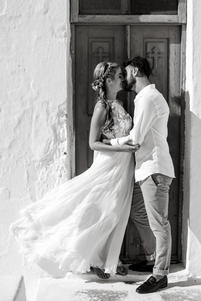 Bride and groom pose for couple's portraits in doorway of Santorini villa