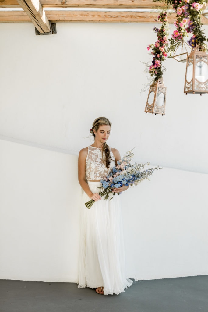 Bride holds pastel colored bouquet for Santorini elopement