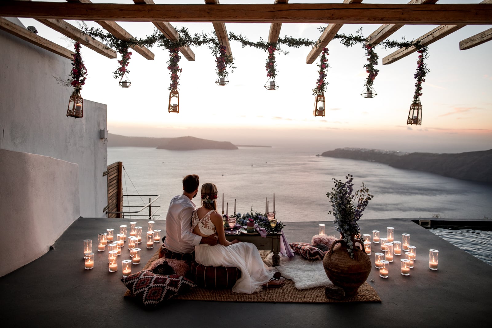 Bride and groom watch the sunset over the ocean from their private balcony intimate reception