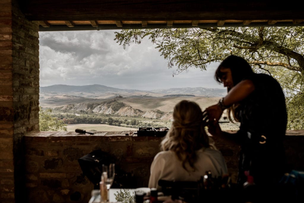 Bride gets ready for wedding ceremony with view of Tuscany, Italy