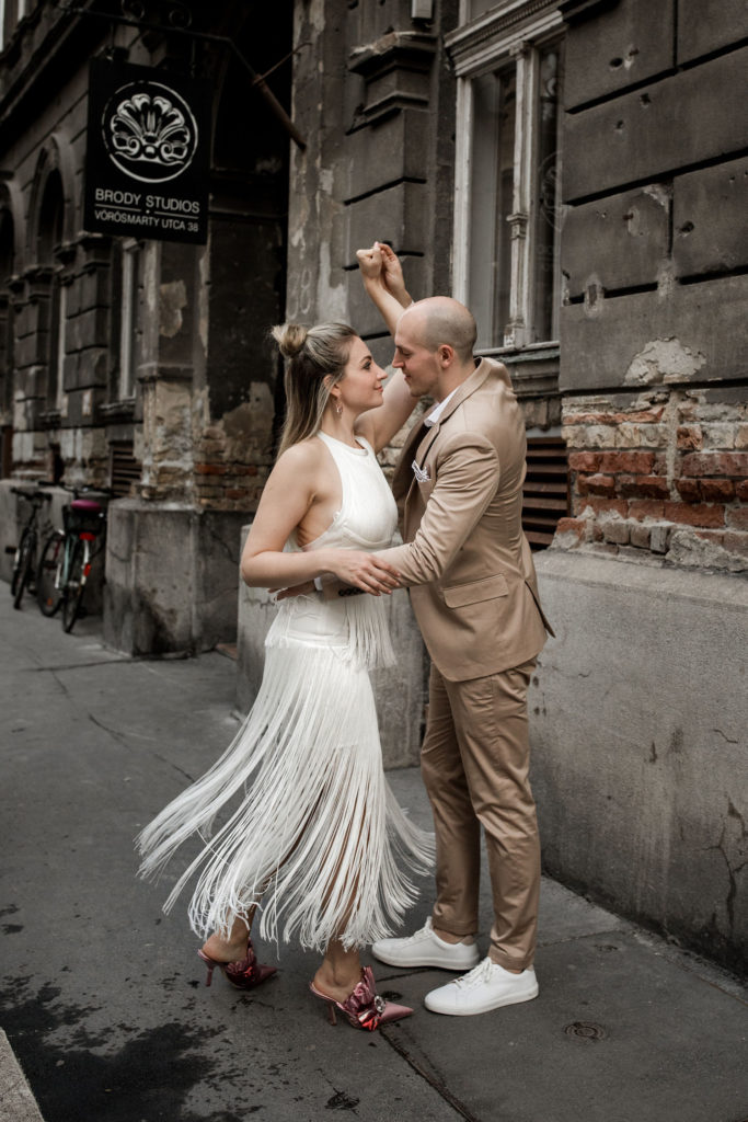 Bride and groom dance in teh streets of Budapest
