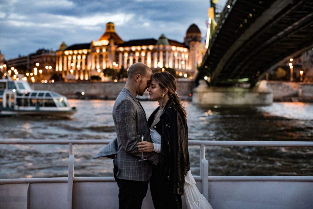 Couple embrace on a cruise boat at dusk in Budapest, Hungary