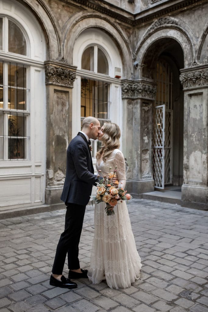 Bride and groom kiss in the Vajdahunyad Castle, Budapest courtyard