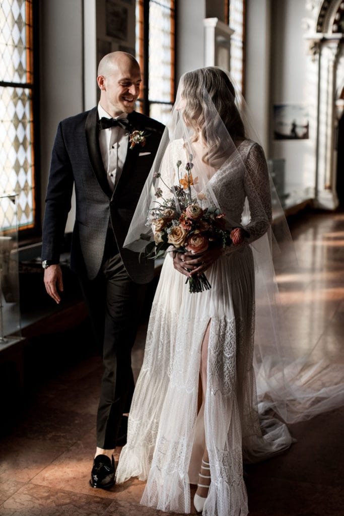 Bride and groom walk halls of Vajdahunyad Castle after Budapest wedding ceremony