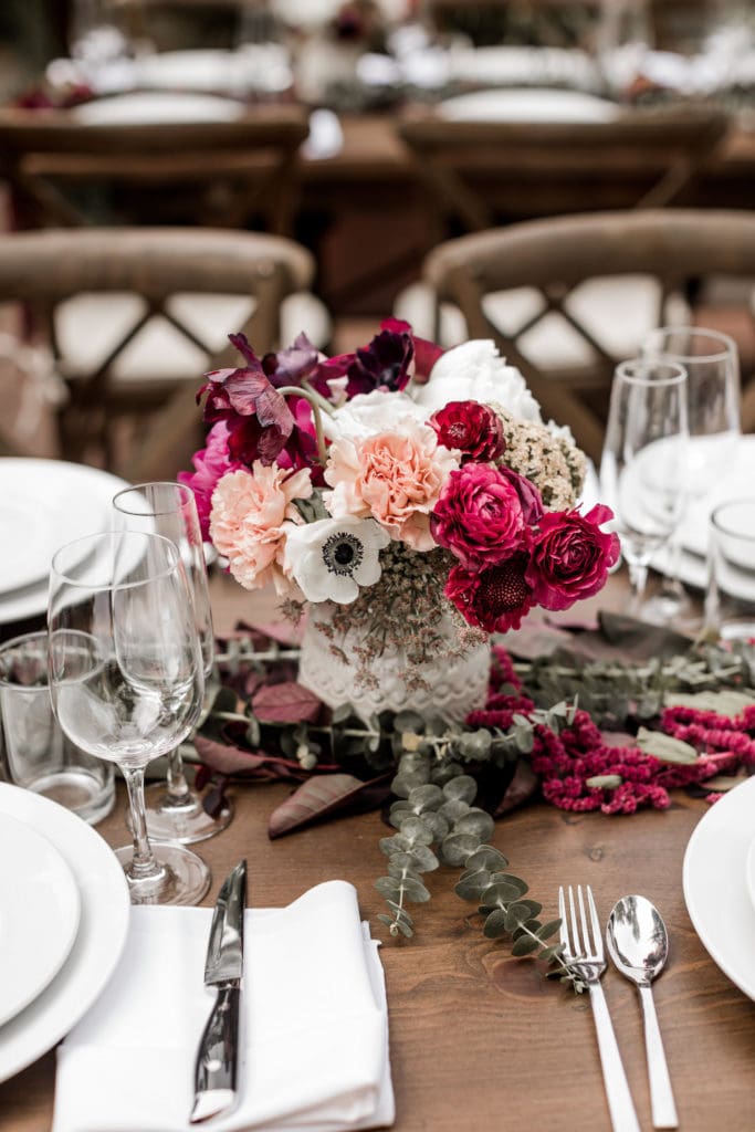 Pink and white floral centerpiece on wedding reception table