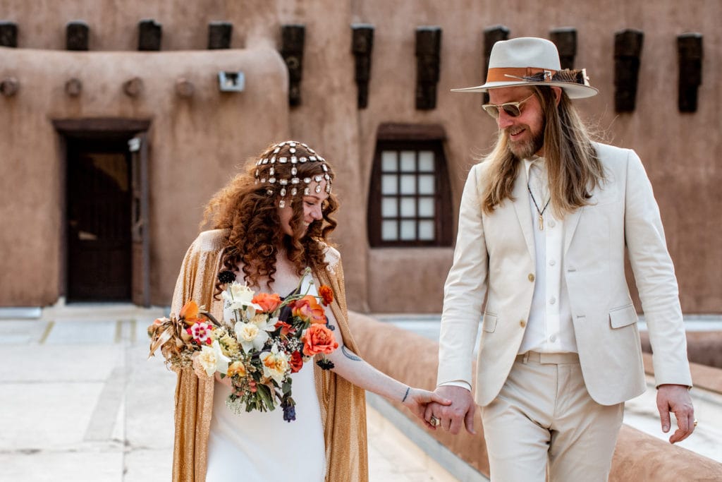 Bride and groom walk hand in hand during their first look before their New Mexico wedding ceremony