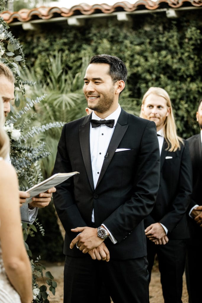 Groom stands with groomsmen colony palms hotel wedding