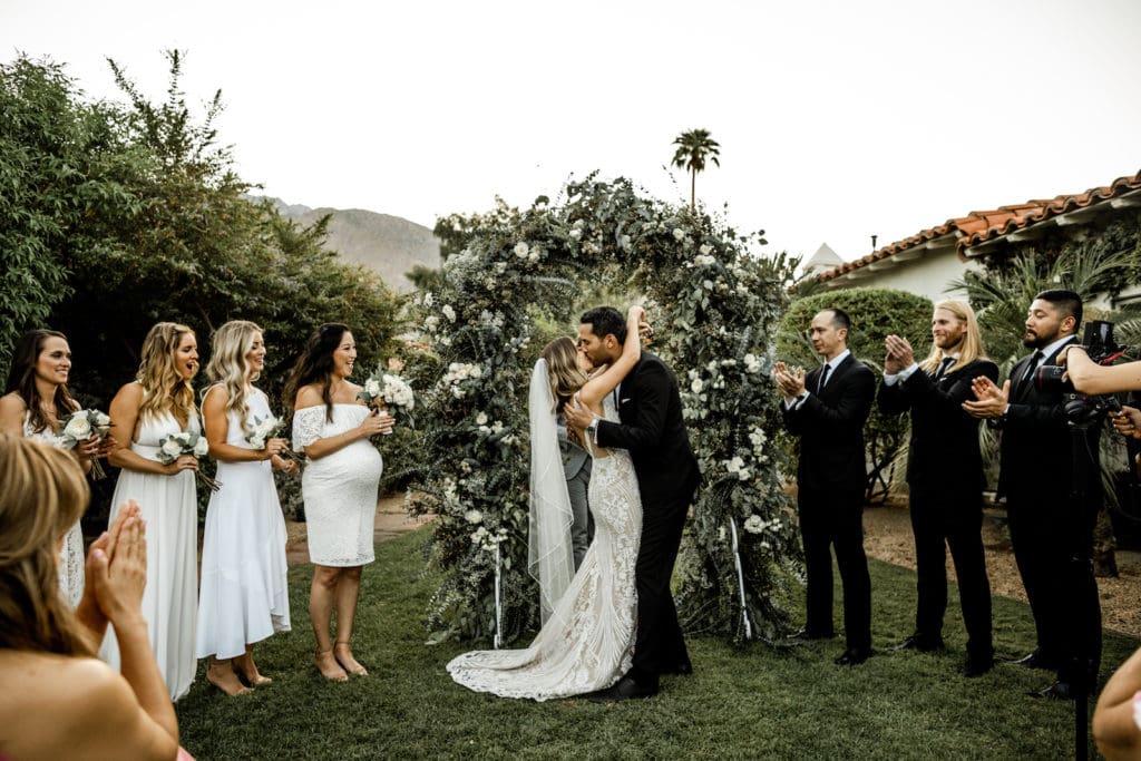 Bride and groom kiss at ceremony altar during Palm Springs California wedding