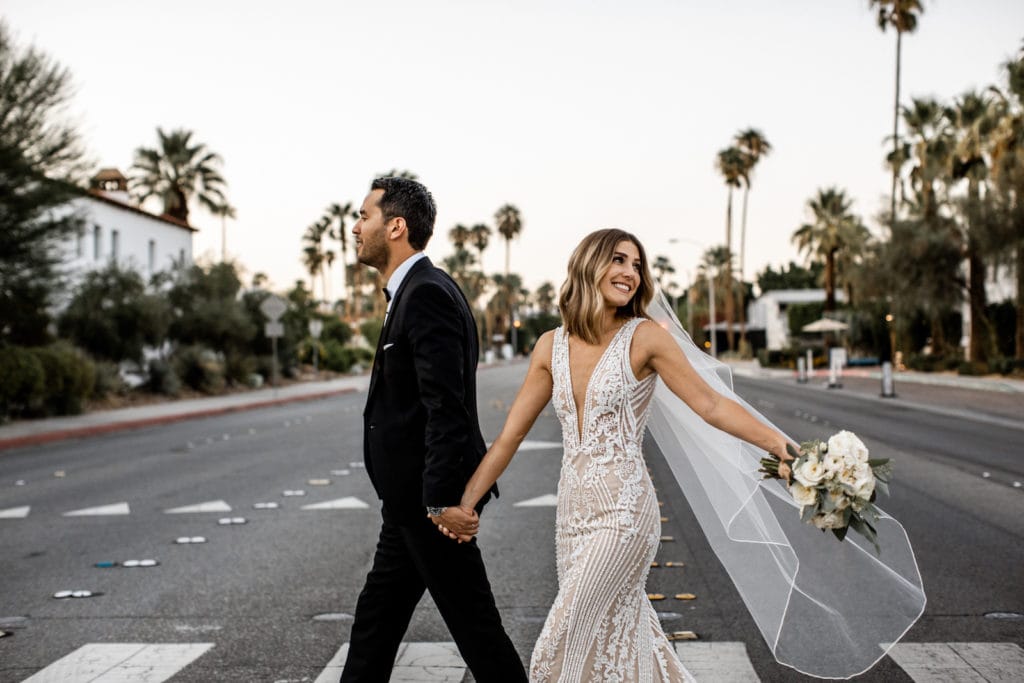 Bride and groom walking streets of downtown Palm Springs California after wedding