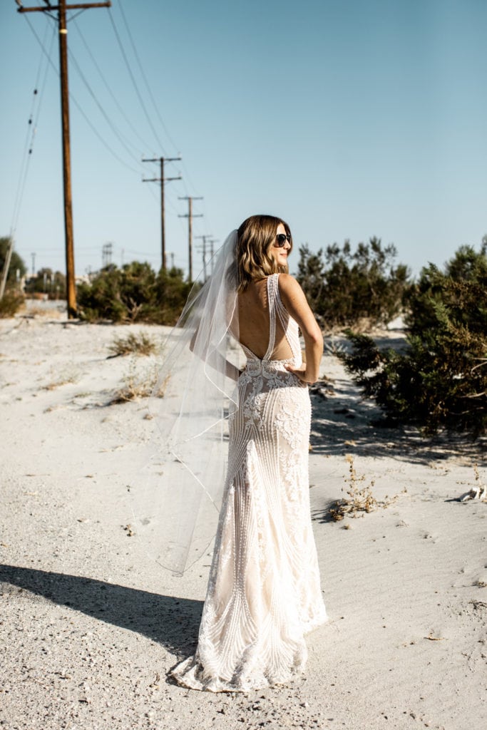 Bride shows back of gown in Palm Springs desert