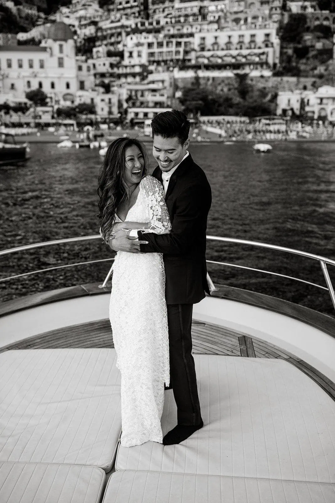 Married couple embrace on boat in Positano Italy