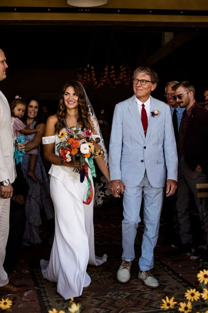 Bride and father walk down the aisle at wedding ceremony