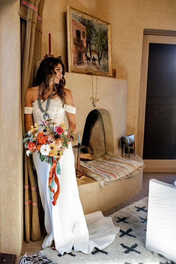 Bride wears Vera Wang bridal gown and holds a bright wildflower bouquet