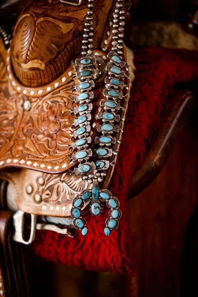 Turquoise statement necklace against leather saddle