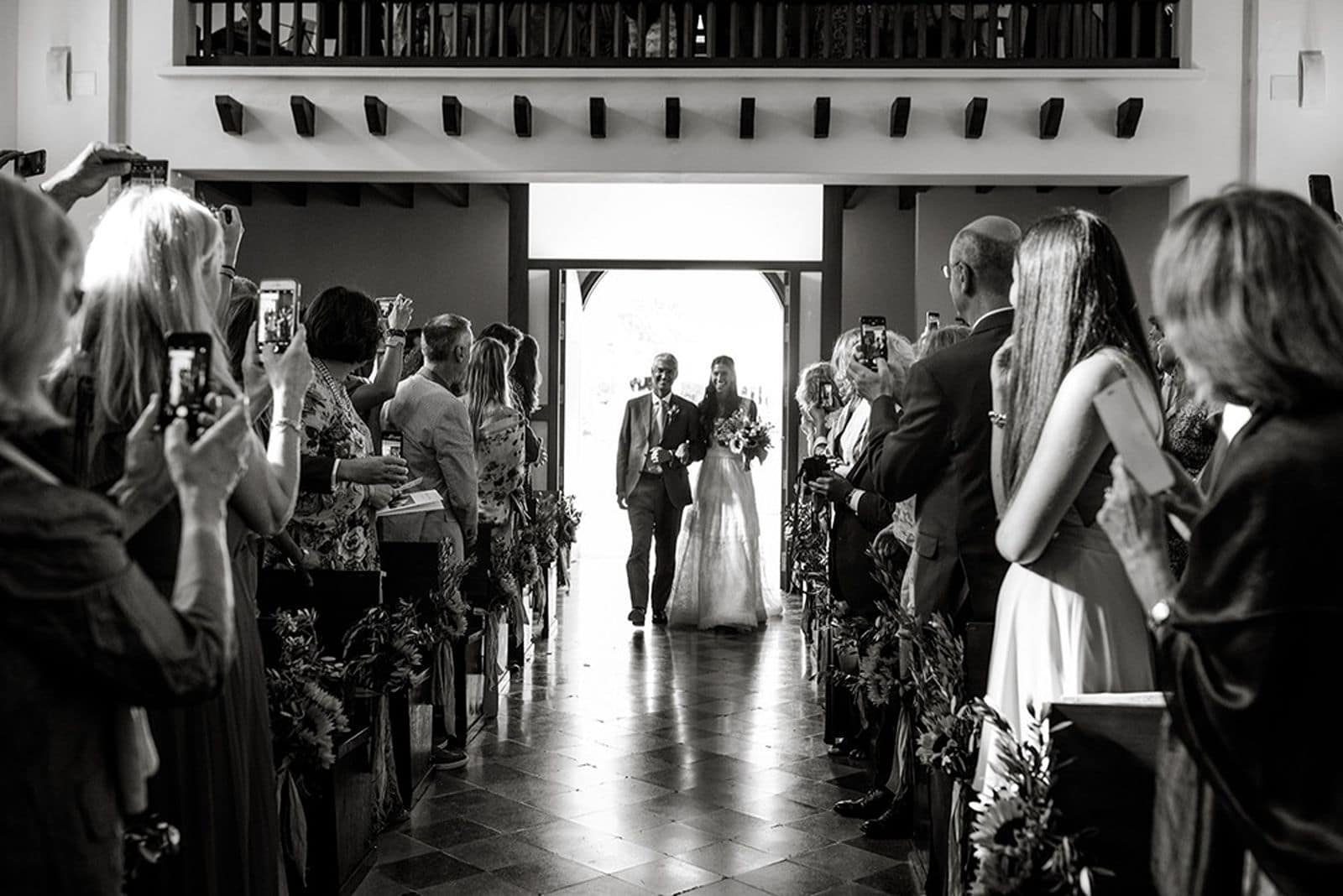 Bride and father walk down wedding ceremony aisle at Iglesia Es Cubells in Ibiza
