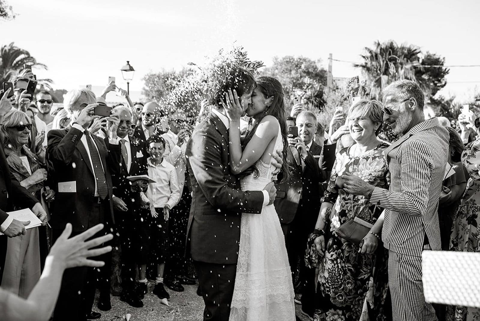 Bride and groom kiss in front of guests after wedding ceremony