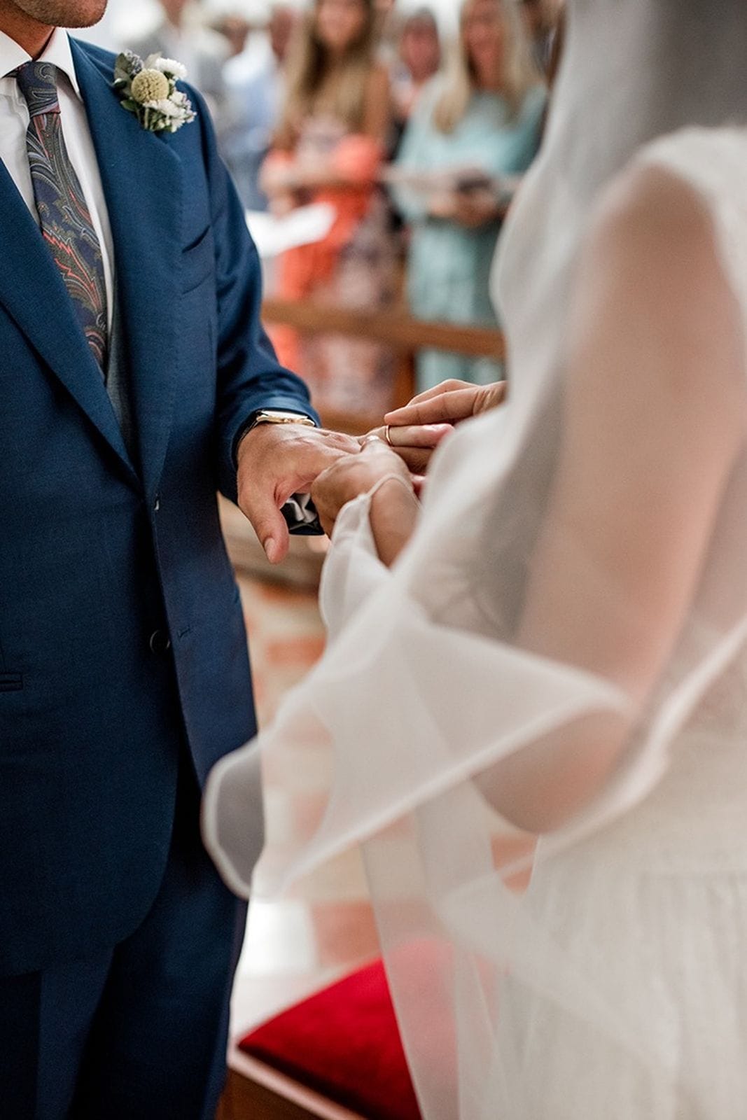 Groom places wedding ring on bride's finger during wedding ceremony