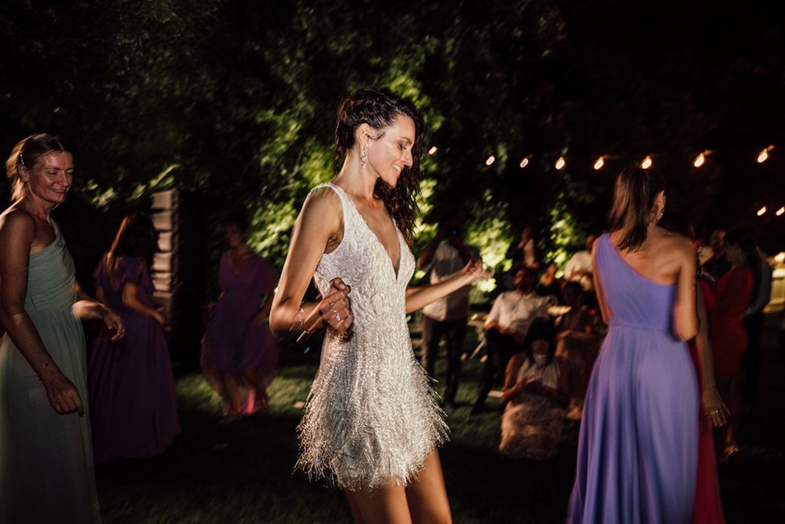 Bride dances in a cocktail dress at an Italian garden wedding reception