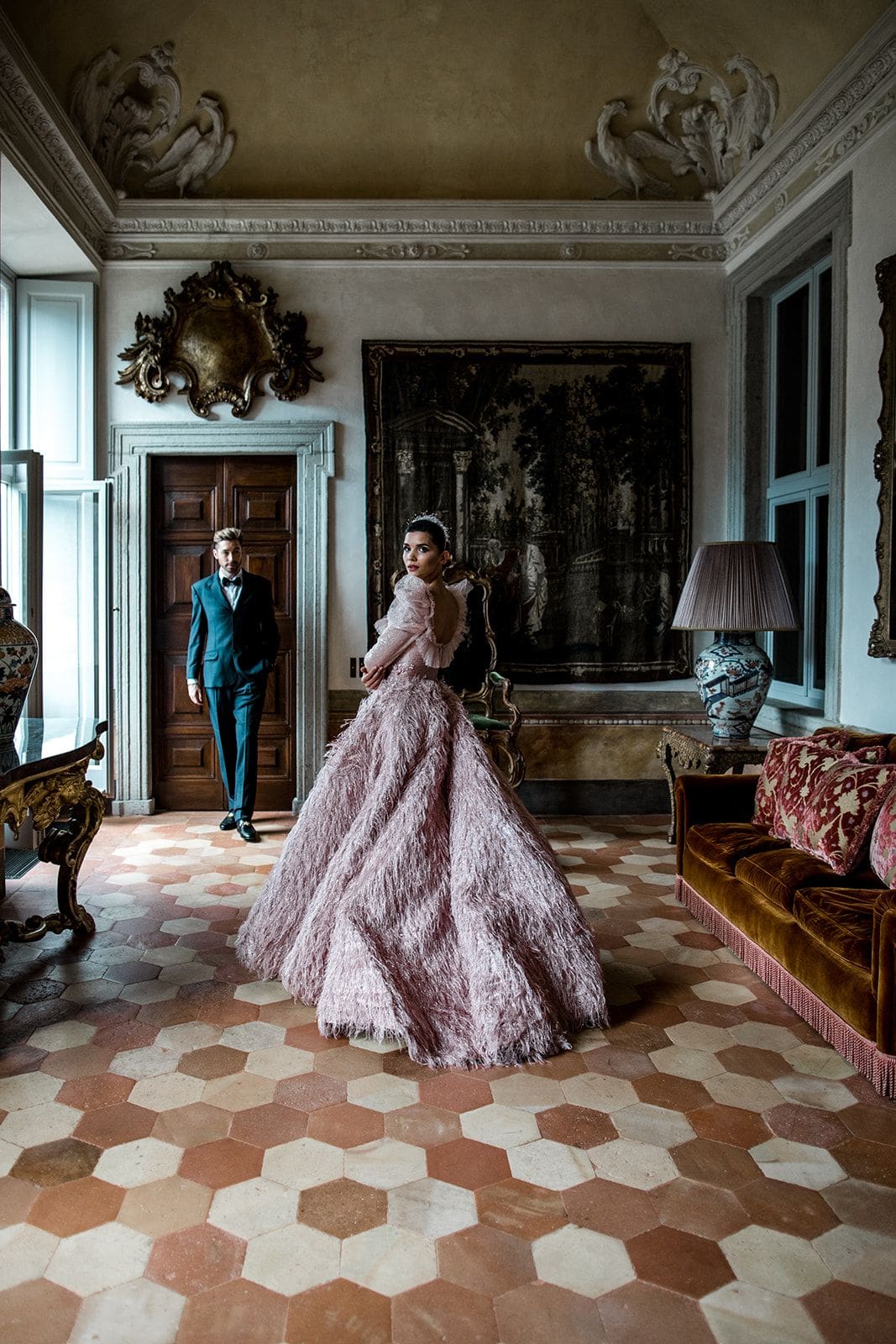 Bride looks back at camera, wearing a pink couture gown, during first look for elopement in Lake Como
