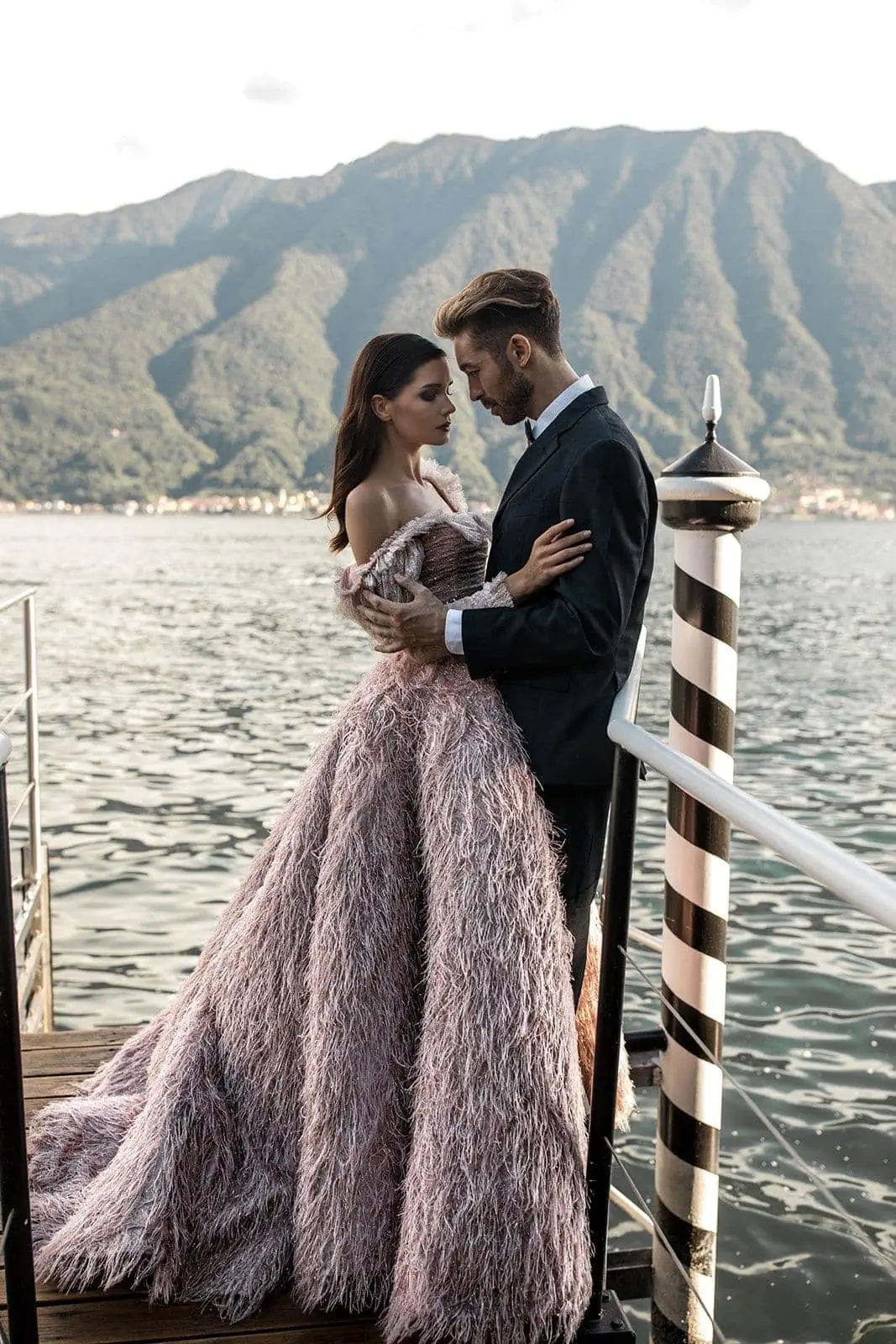 Bride and groom embrace with Lake Como in the background