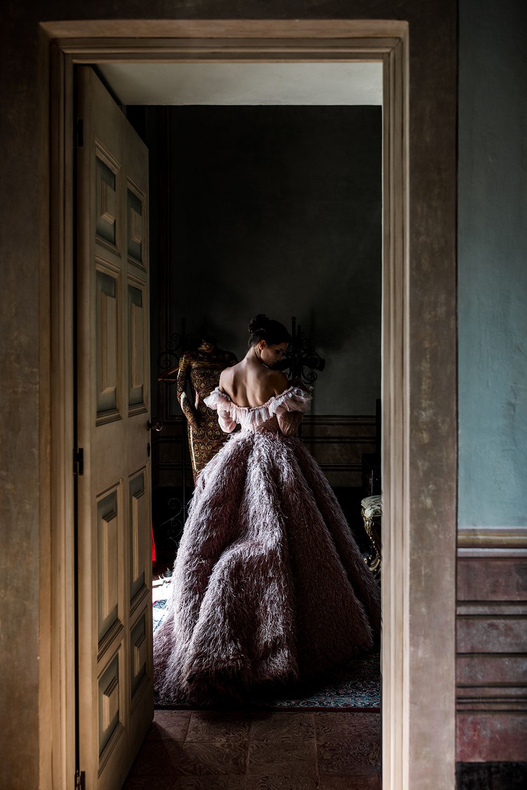 Bride slips into pink couture gown standing in doorway at Villa Balbiano