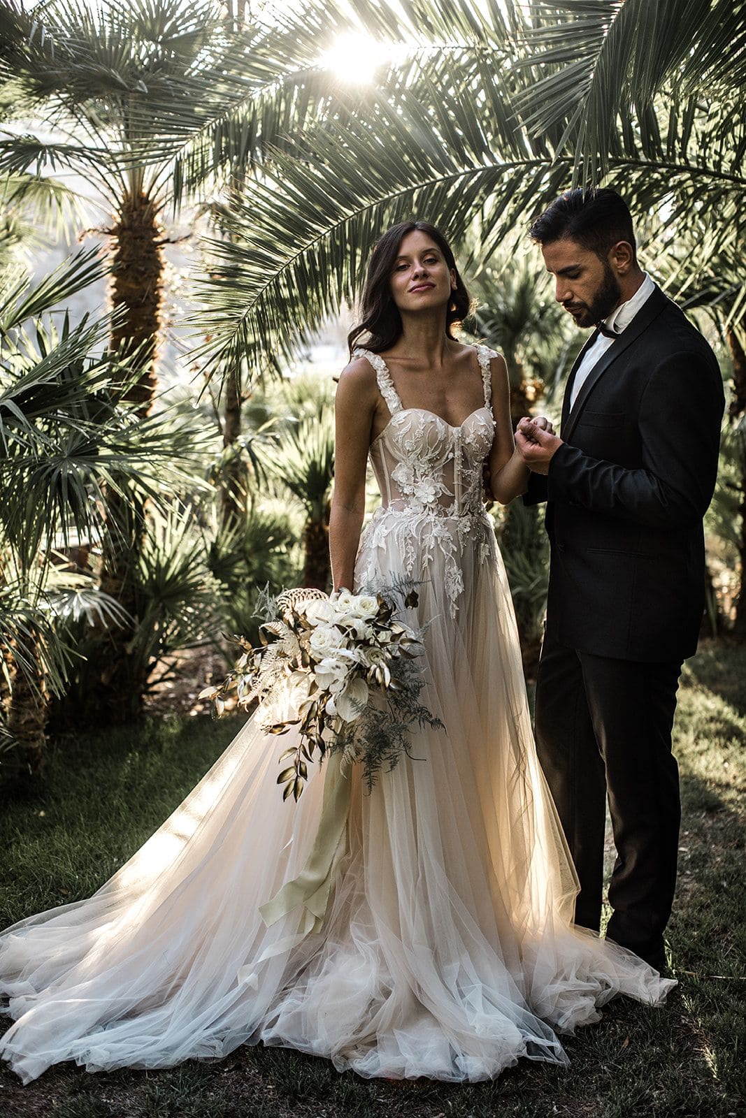 Bride and groom stand together in tropical garden in Amalfi Coast