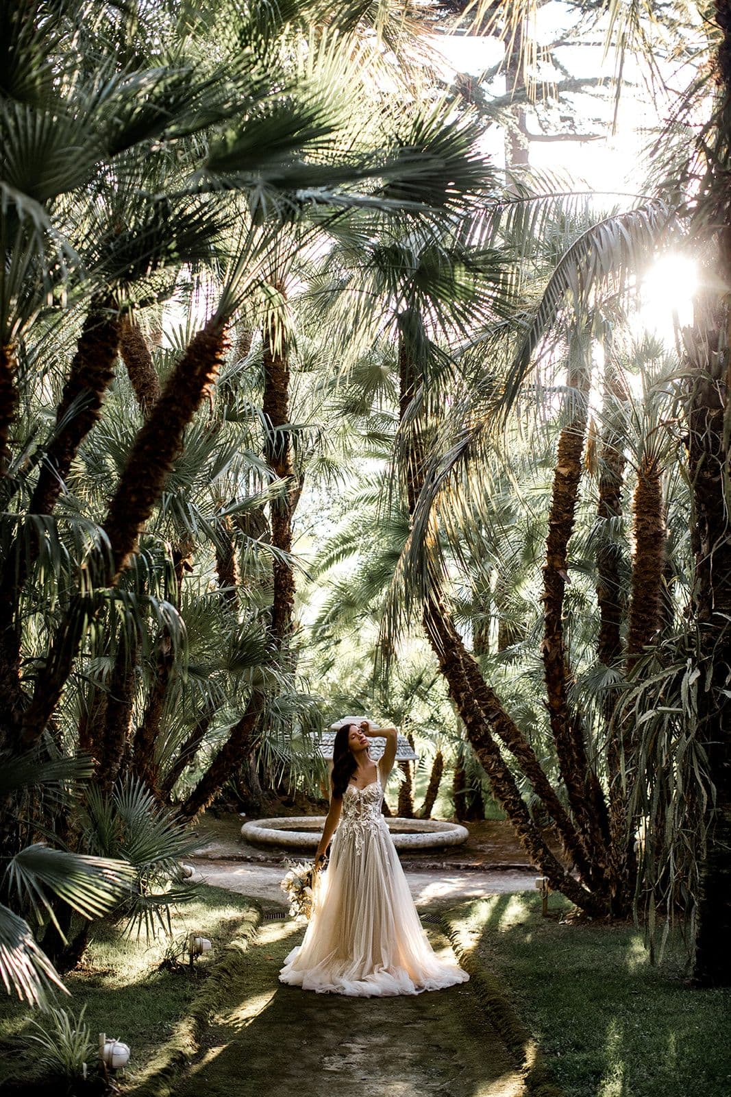 Bride stands in tropical garden of Villa Astor before Amalfi Coast elopement