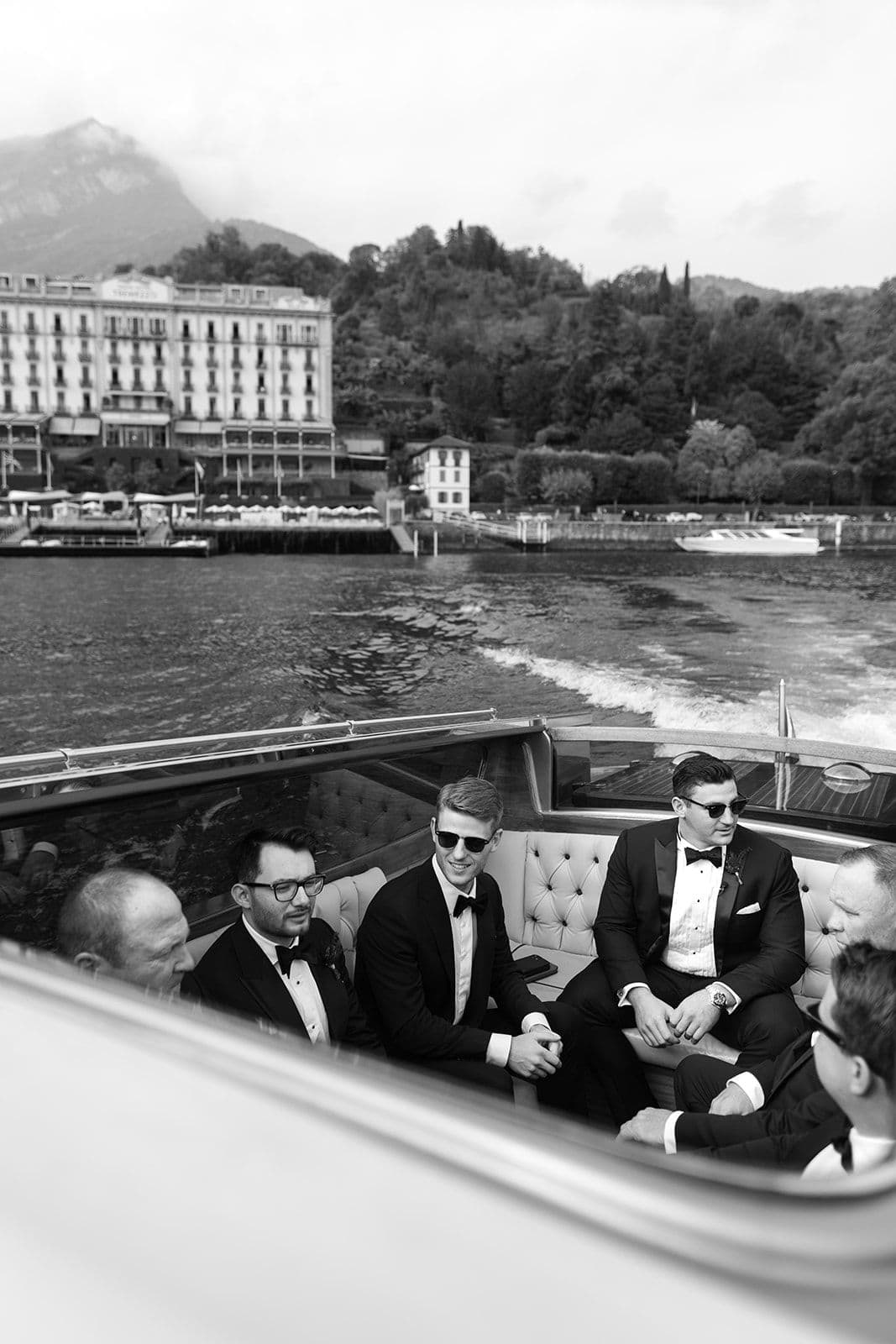 Groomsmen in boat on Lake Como with Grand Hotel Tremezzo in background