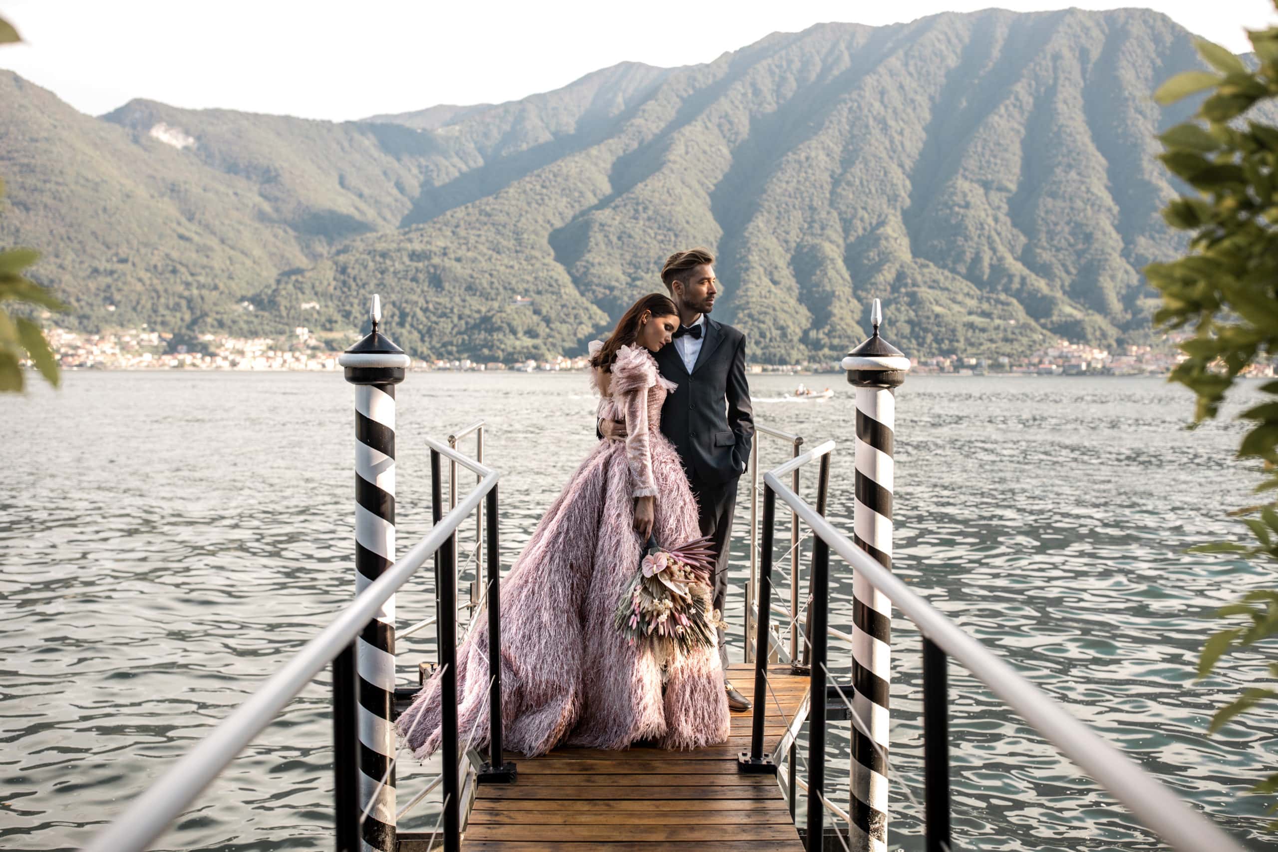 Bride and groom stand on dock at Villa Balbiano during elopement in Lake Como