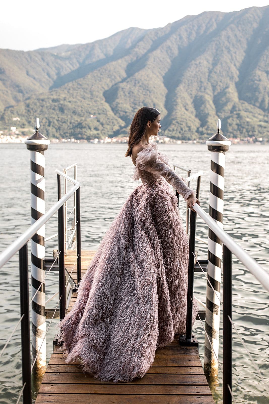 Bride stands on dock at one of the top Lake Como wedding venues, Villa Balbiano