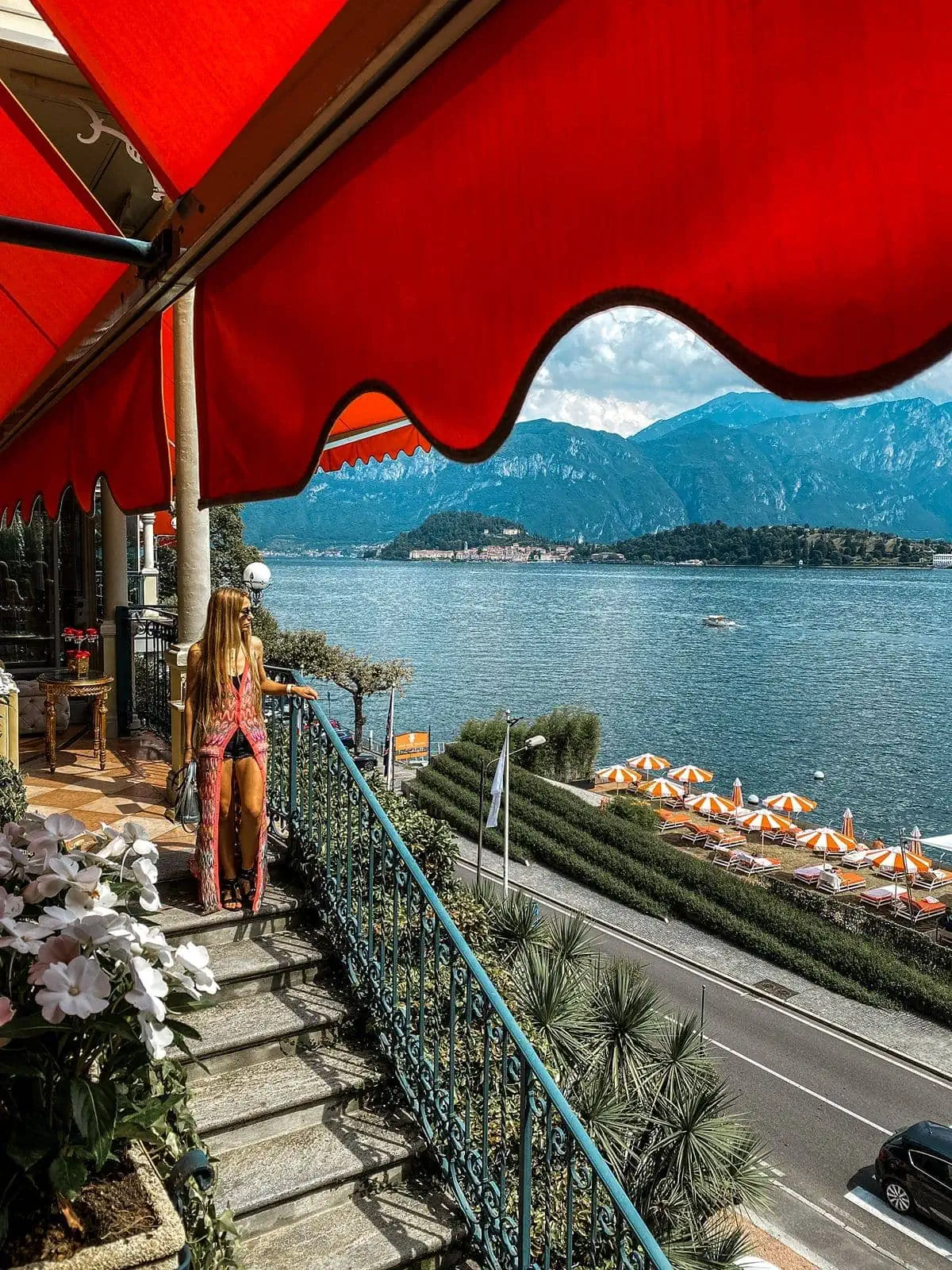 Woman stands at staircase at Grand Hotel Tremezzo overlooking Lake Como