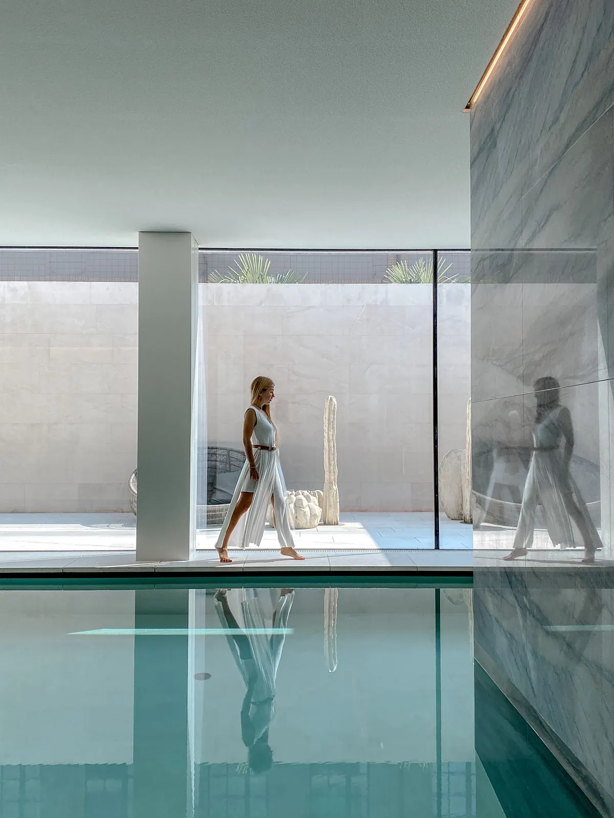 Woman walks by pool inside Hilton Lake Como