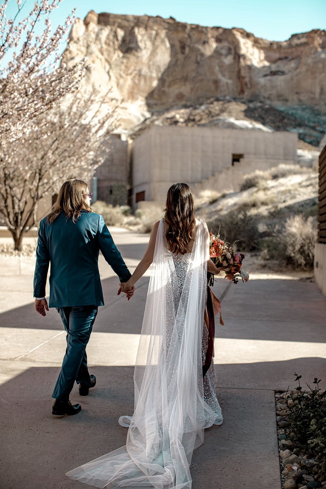 Bride and groom walk through Amangiri in Utah