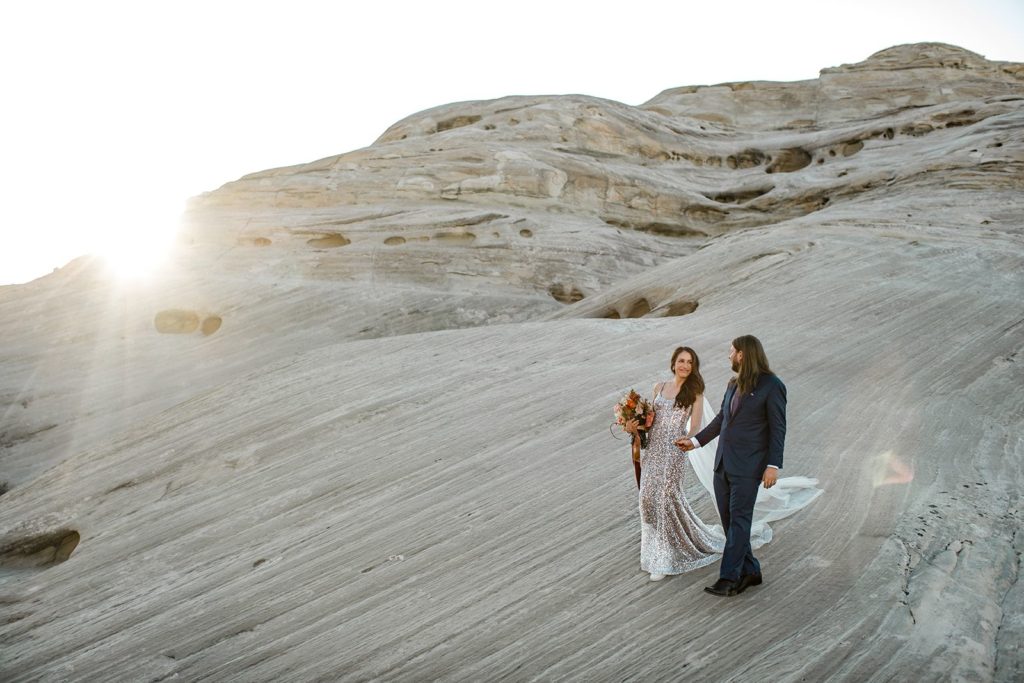 Bride and groom walk during portraits after Amangiri elopement in Utah