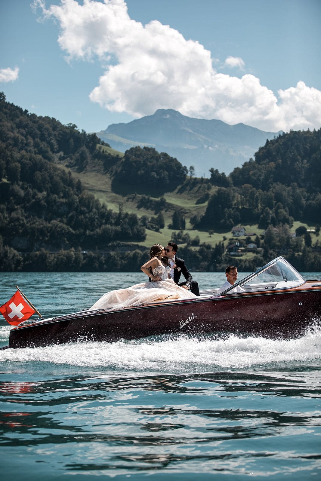Bride and groom kiss during Lake Lucerne wedding boat ride
