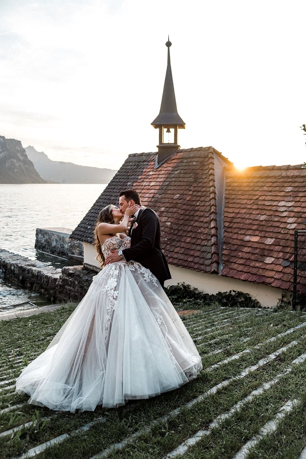 Bride and groom kiss for sunset portraits after Lake Lucerne wedding